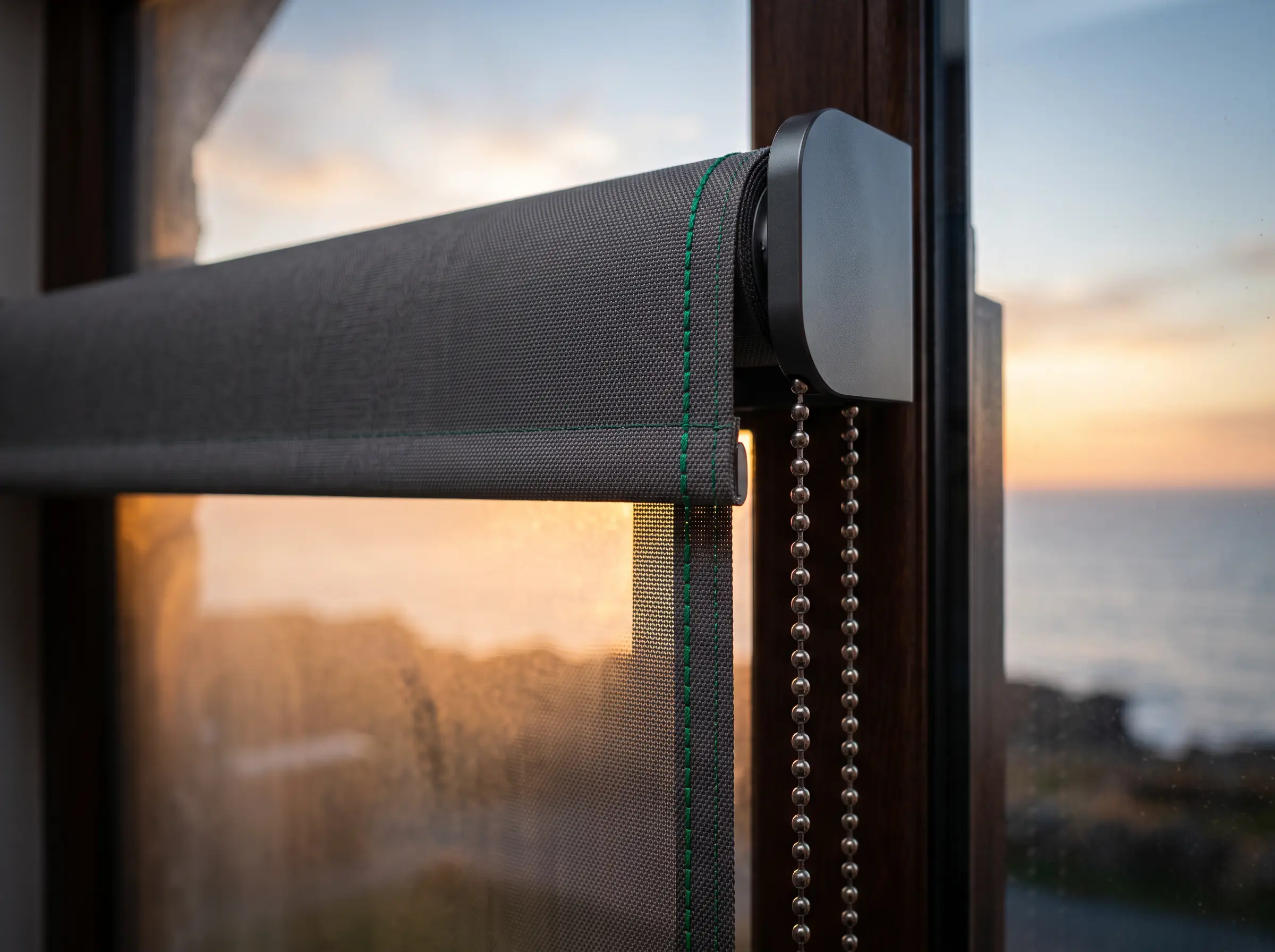 Roller tube, end bracket and mesh edge on a Clifton window — the parts that have to survive the salt air
